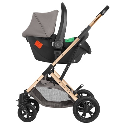 Carrinho de bebé com estrutura dourada, assento cinzento, capota cinzenta e rodas pretas