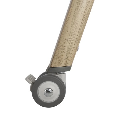 Roda pequena cinzenta com trava fixada em estrutura de madeira clara