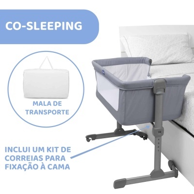 Berço de co-sleeping cinzento com laterais brancas junto a cama com roupa branca