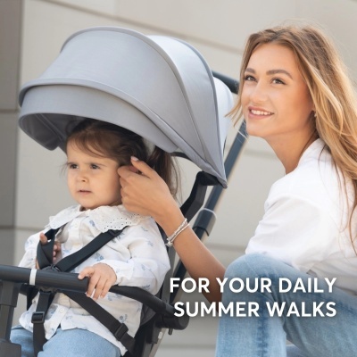 Carrinho de bebé cinzento com criança e mãe ao lado