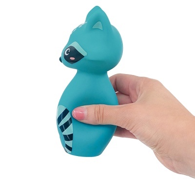 Figura de guaxinim azul em borracha segurada por mão humana