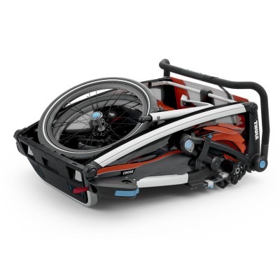 Carrinho de bebé dobrado vermelho e preto com estrutura metálica e rodas