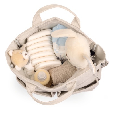 Mala de tecido bege com fraldas, peluches, biberão e objeto de malha.