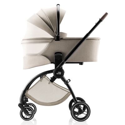 Carrinho de bebé bege com estrutura preta e rodas duplas