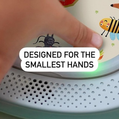 Mão tocando objeto com padrão de abelhas e texto em inglês 'DESIGNED FOR THE SMALLEST HANDS'