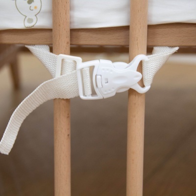 Cinta branca com fivela de plástico presa a barras de madeira clara