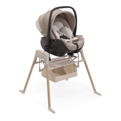 Cadeira auto para bebé bege e preto com suporte alto de pernas em madeira.
