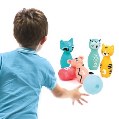 Criança a jogar boliche com pinos de animais coloridos