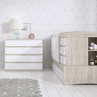 Quarto infantil com berço de madeira clara, cômoda branca, candeeiro e tapete cinzento