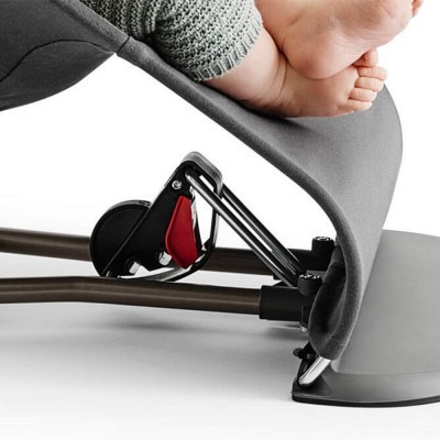 Pé de bebé numa estrutura metálica com revestimento cinzento e peça preta e vermelha