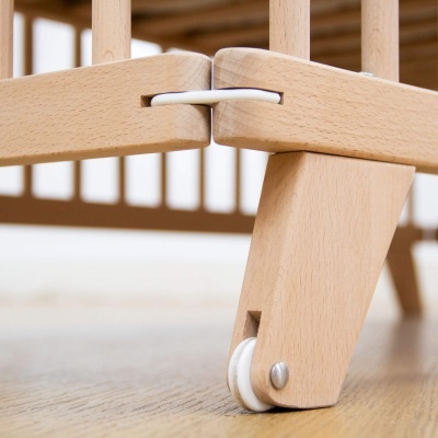 Rodízio branco em cone de madeira clara de mobília em chão de madeira.