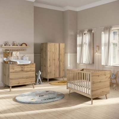 Quarto de bebé com móveis de madeira clara e cortinas brancas