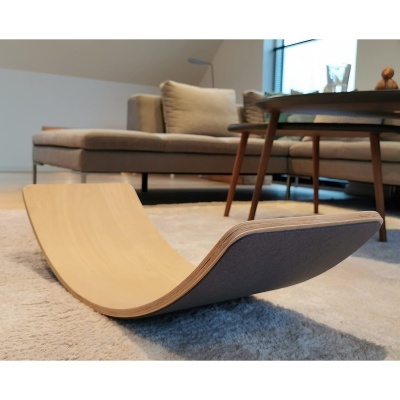 Balanço em madeira curva clara e tecido cinza sobre tapete em sala de estar moderna