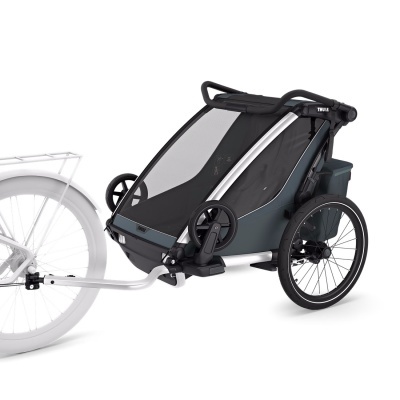 Carrinho de bicicleta infantil Thule preto e cinza ligado a bicicleta branca