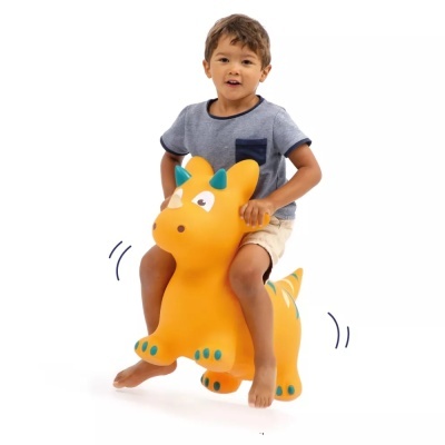 Menino numa cadeira insuflável em forma de dinossauro laranja