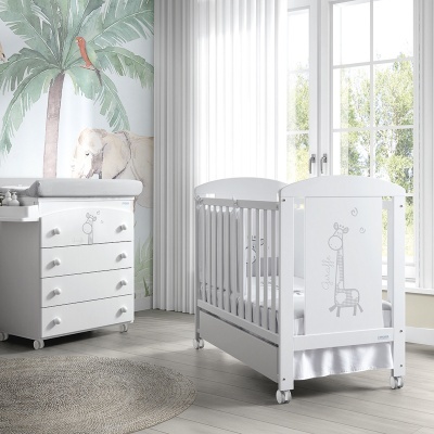 Quarto de bebé com berço e cómoda brancos com desenhos de girafas cinzentas e papel de parede de elefante e folhas verdes