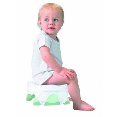 Bebé sentado num penico plástico verde com cobertura branca