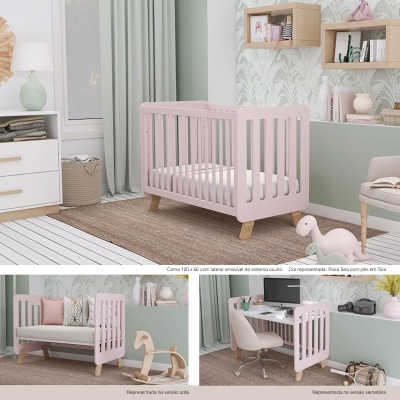 Berço/cama multifuncional rosa com laterais móveis e pés em madeira clara num quarto decorado.