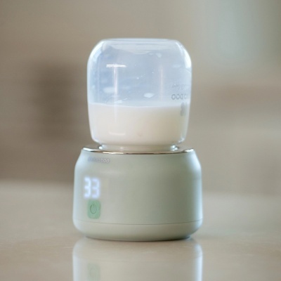 Aparelho moderninho para aquecer leite com recipiente transparente e base creme com visor digital