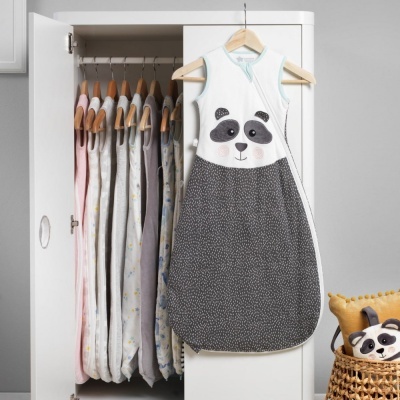 Saco de dormir para bebé com padrão de panda pendurado em guarda-roupa branco