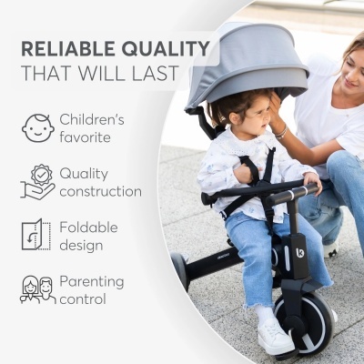 Criança num triciclo preto com capacete, mulher ao lado, texto promocional em fundo claro