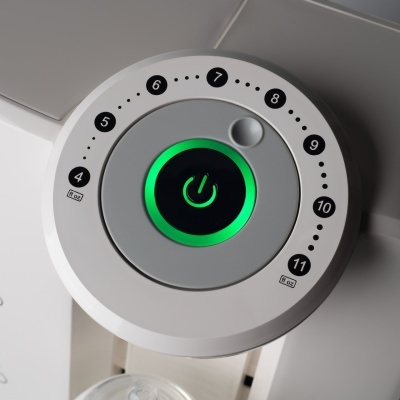 Botão redondo de máquina branca com números e luz verde