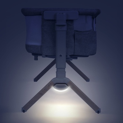 Berço de bebé com madeira clara, tecido cinzento, iluminação integrada na base.