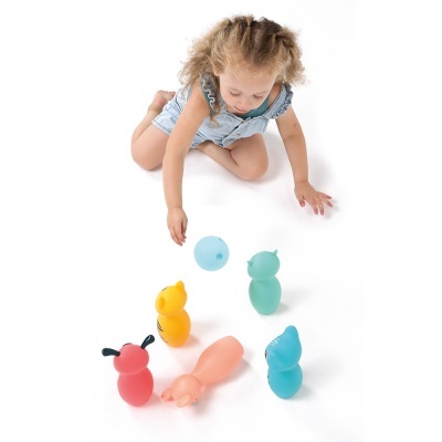 Menina a brincar com brinquedos coloridos de silicone em forma de animais