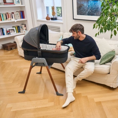 Berço portátil para bebé com estrutura em madeira e metal e superfície em tecido cinzento escuro