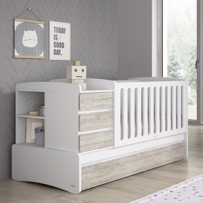 Berço branco de bebé com gavetas em madeira clara e prateleiras, painel decorativo na parede