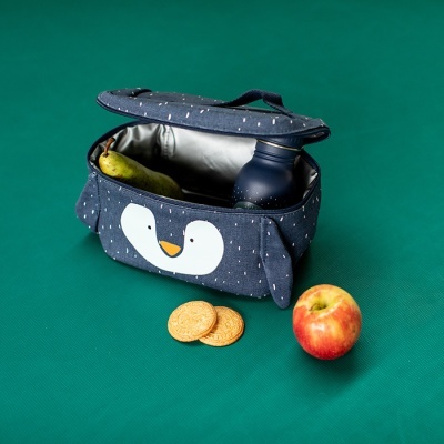 Bolsa térmica azul com desenho de pinguim, aberta com garrafa e pera dentro, à frente maçã e bolachas