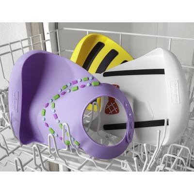 Três escudos faciais de plástico coloridos dentro de uma máquina de lavar louça.