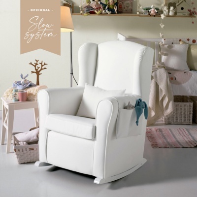 Cadeirão branco de madeira tipo baloiço com almofada num quarto infantil com decoração clara.