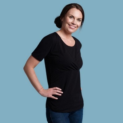 Mulher a usar camisola preta de manga curta e jeans azuis num fundo azul claro.