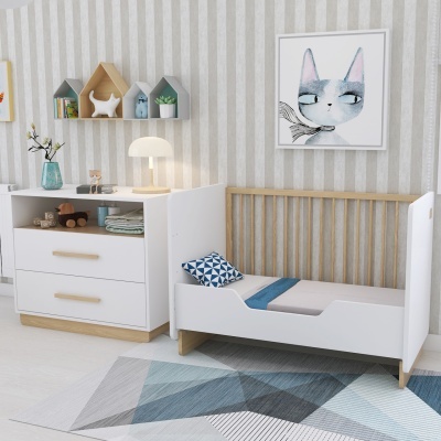 Cama infantil branca e madeira clara com cómoda e decoração infantil num quarto