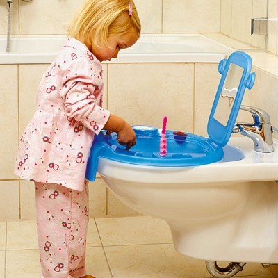 Criança a usar redutor de sanita infantil azul num casa de banho