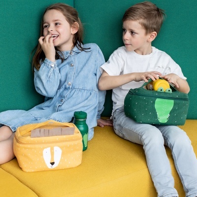 Crianças sentadas com bolsas térmicas coloridas e brinquedos