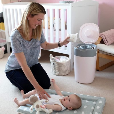 Fraldaira automática e mãe a mudar fraldas de bebé num quarto cor-de-rosa