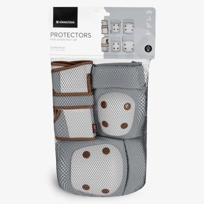 Conjunto de proteções para crianças com cotoveleiras, joelheiras e protetores de punho cinza e bege, embalagem em rede preta.
