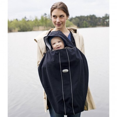 Capa preta para bebé usada por mulher junto a lago