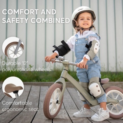 Criança com capacete numa bicicleta de equilíbrio cinzenta