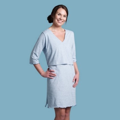 Mulher com vestido cinzento claro de manga 3/4 e decote em V, fundo azul.