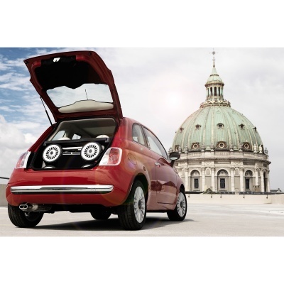 Carro vermelho com sistema de som na bagageira aberta e cúpula histórica ao fundo