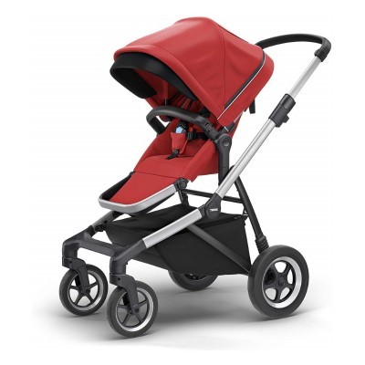 Carrinho de bebé vermelho com estrutura metálica prateada e rodas pretas em fundo branco