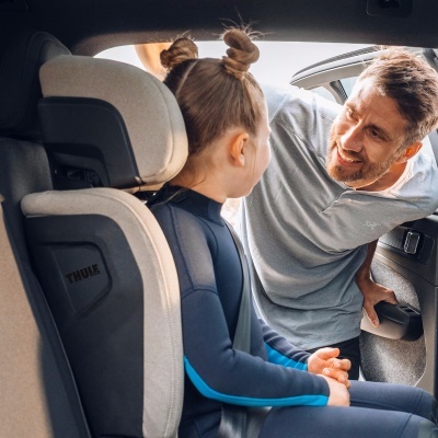 Cadeira auto para criança cinzenta da Thule no carro com criança e adulto