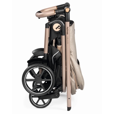 Carrinho de bebé dobrado em metal rosa dourado e preto com tecido bege