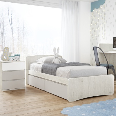 Cama individual branca com gavetas, roupa de cama cinzenta e branca e peluche, ao lado cama de cabeceira branca num quarto claro