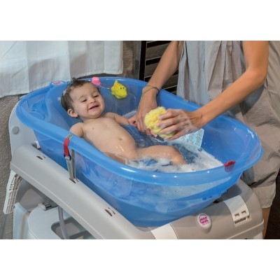 Banheira azul transparente para bebé em suporte branco com criança a ser lavada