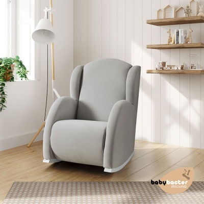 Cadeirão de amamentação cinza em sala clara com chão de madeira e candeeiro