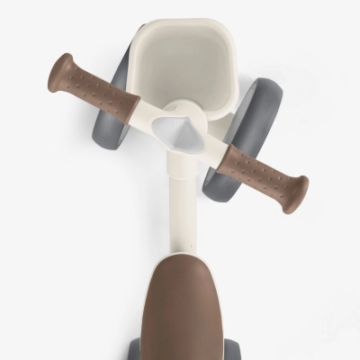 Triciclo infantil castanho, cinzento e branco visto de cima